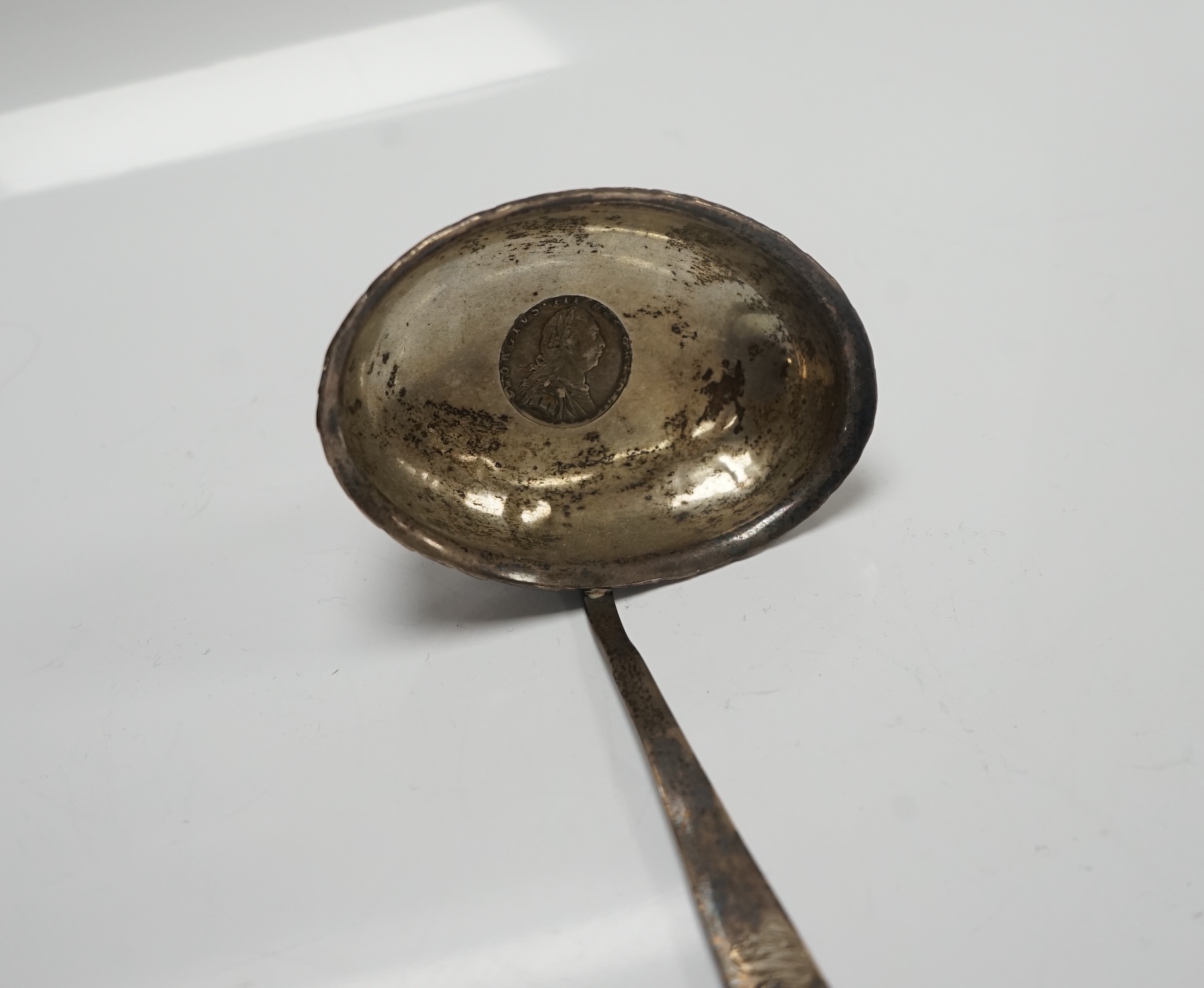 A George III white metal toddy ladle, with baleen handle and inset coin bowl, 38.5cm, unmarked. Condition - poor to fair